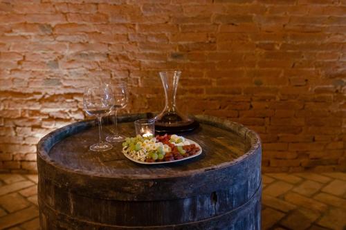 a table with a plate of food and wine glasses at Vinný sklep Rozárka in Drnholec