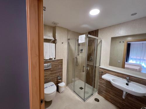 y baño con ducha, aseo y lavamanos. en Apartamentos Flamingo Hills, en Benitachell