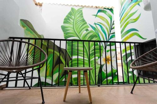 a room with two chairs and a wall with a mural at Apartamento Milano, Living Suites en Vila real in Villareal