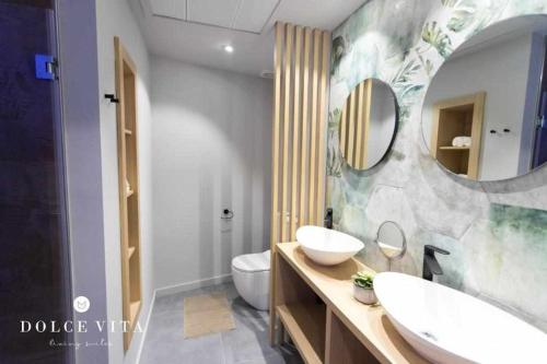 a bathroom with a sink and a toilet and a mirror at Apartamento Milano Living Suites en Vila real in Villareal