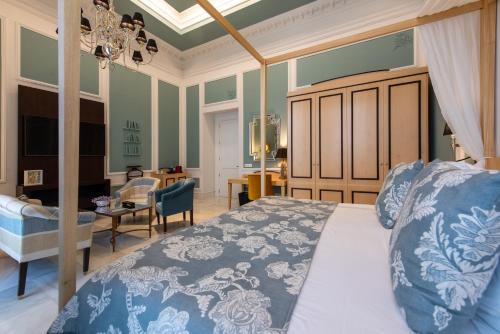 a bedroom with a bed and a living room at Hotel Casa Palacio María Luisa in Jerez de la Frontera