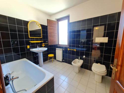 a bathroom with a tub and a sink and a toilet at Villa To' - Arbatax, Porto Frailis in Àrbatax