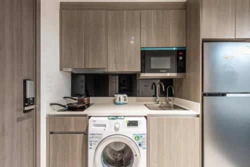 a kitchen with a washing machine and a refrigerator at Circle Rein Sukhumvit 12 #1BR#Pool&Gym#Near Terminal 21#Max2 in Bangkok