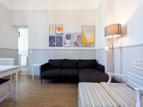 ein Wohnzimmer mit einer schwarzen Couch in einem Zimmer in der Unterkunft Villa Amelia, App. 07 in Heringsdorf