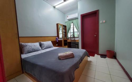 a bedroom with a bed with a suitcase on it at Putrajaya Transit Romestay in Putrajaya