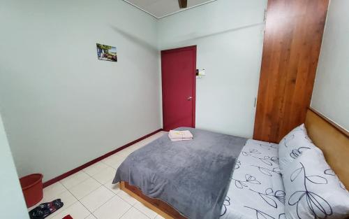 a bedroom with a bed and a red door at Putrajaya Transit Romestay in Putrajaya