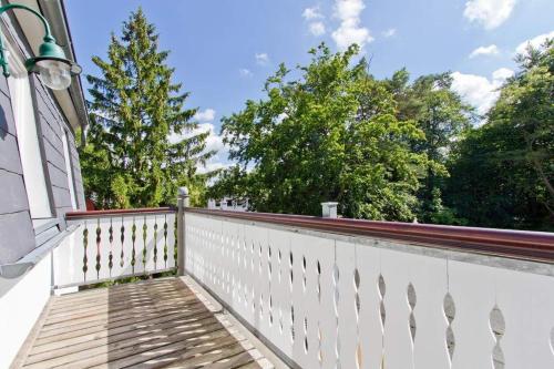 una recinzione bianca su una casa con alberi sullo sfondo di Villa Amelia App 12 a Heringsdorf