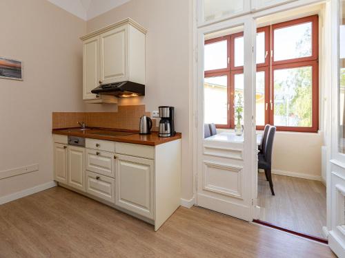 eine Küche mit weißen Schränken und einer Arbeitsplatte in der Unterkunft Villa Arcadia, App. 05 in Heringsdorf