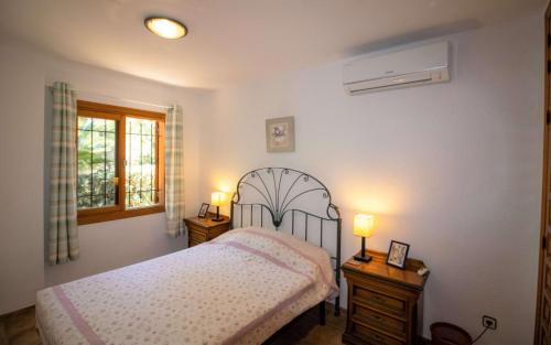 1 dormitorio con 1 cama con 2 mesitas de noche y 2 lámparas en Villa con jardin y piscina privada ALCOSSEBRE Albert Villas en Alcocéber