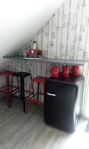 a black refrigerator with red cups on top of it at Hébergements indépendants chez l'habitant in Saint-Mars-dʼOutillé