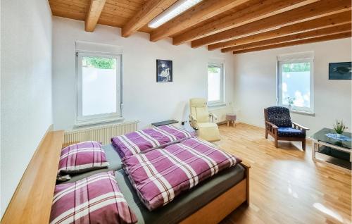 a bedroom with a bed and a desk and two windows at Cozy Apartment In Ditfurt With Wifi in Ditfurt