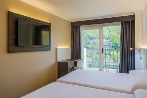 a hotel room with a bed and a window at Hotel Rosaleda del Mijares in Montanejos