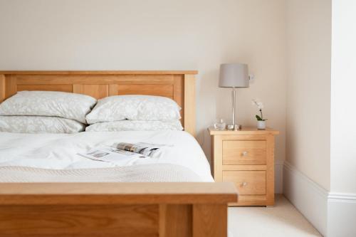 a bedroom with a wooden bed and a night stand at Craigard Lodge - Seasgair Lodges in Boat of Garten