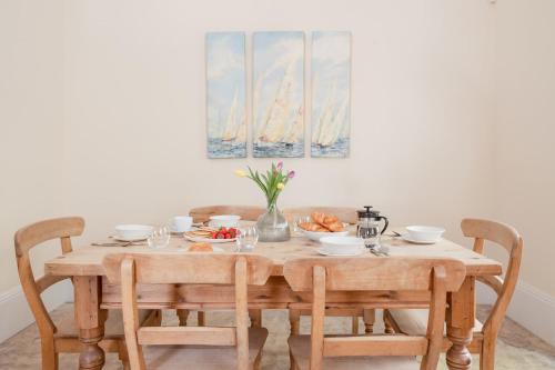 a wooden table with chairs and a table with food on it at Craigard Lodge - Seasgair Lodges in Boat of Garten