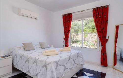 1 dormitorio con 1 cama con cortinas rojas y ventana en Villa Meretseger, en Almogía