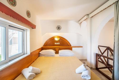 a bedroom with a bed with two towels on it at Olympus Tilos Apt double A2 in Livadia