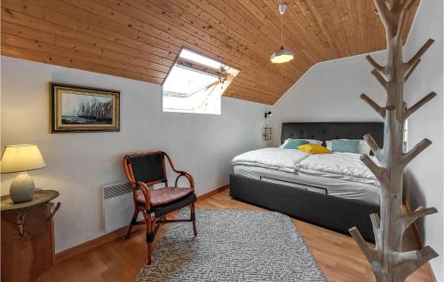 ein Schlafzimmer mit einem Bett, einem Stuhl und einem Baum in der Unterkunft Stunning Home In Plouguerneau With Kitchen in Plouguerneau