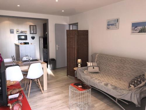 une chambre avec un lit et une table et une cuisine dans l'établissement Charmant T2 rénové, 4 couchages, parking privé, 200m plage, balcon, meublé tourisme 2 étoiles - FR-1-224C-179, à Saint-Hilaire-de-Riez