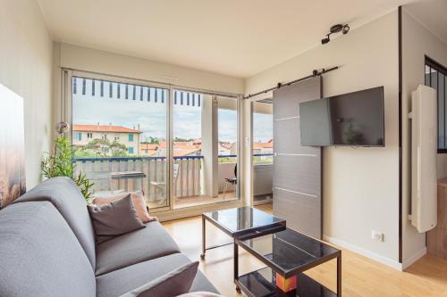 un salon avec un canapé et une télévision dans l'établissement Reine de Serbie, à Biarritz