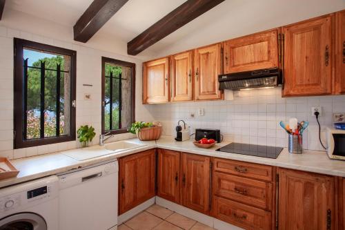 une cuisine avec des armoires en bois et un évier dans l'établissement Davia 1 - Grande terrasse vue panoramique sur la mer, à Corbara