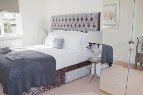 um quarto com uma cama grande e uma grande cabeceira. em Beautiful 3 bedroom house, central Harrogate em Harrogate