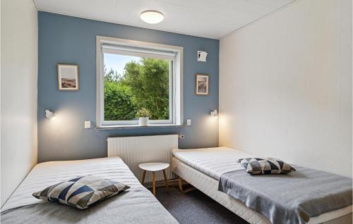 2 Betten in einem Zimmer mit Fenster in der Unterkunft Patalavaca in Blåvand