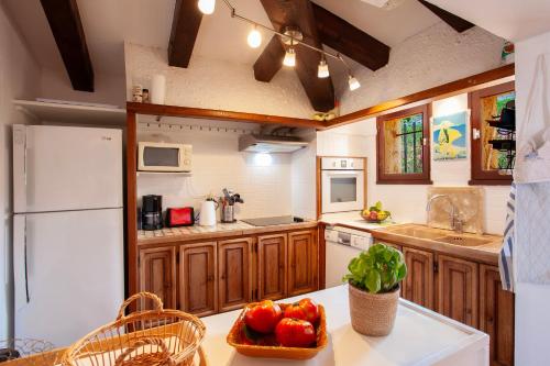 une cuisine avec des armoires en bois et un réfrigérateur blanc dans l'établissement Davia 2 - Grande terrasse vue mer, à Corbara