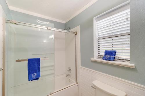 a bathroom with a shower and a toilet and a window at Woodsy Gassville Getaway about 3 Mi to White River! in Gassville