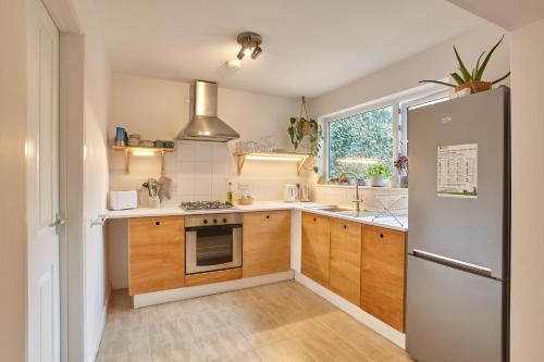 a kitchen with wooden cabinets and a refrigerator at Howlyek, in St Agnes Village in St. Agnes