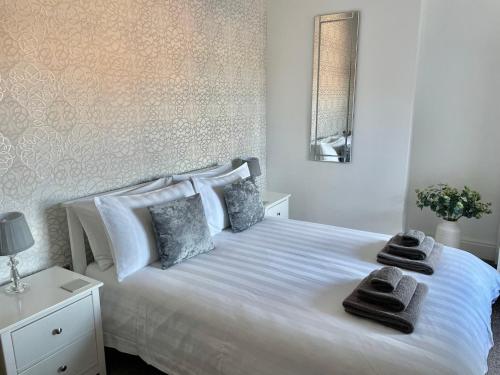 a bedroom with a white bed with towels on it at The Place - Lytham in Lytham St Annes
