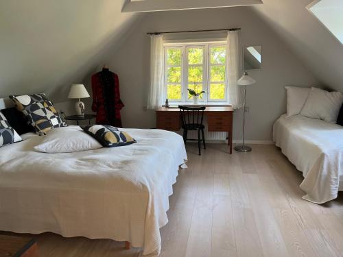 um quarto com 2 camas, uma secretária e uma janela em Fuglsang Bed & Breakfast em Hjørring