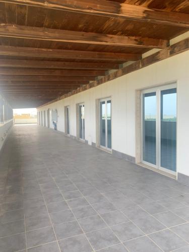 a large empty room with windows and a ceiling at ORION AFFITTACAMERE in Molfetta