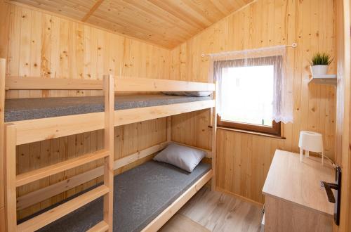 a wooden cabin with two bunk beds in it at Domki pod wzgórzem in Kopań