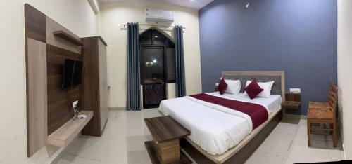 a bedroom with a large bed and a television at L S Haveli in Pushkar