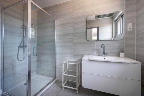 uma casa de banho com um chuveiro, um lavatório e um espelho. em Escapade au Croisic! em Le Croisic