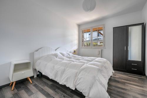 - une chambre blanche avec un grand lit et une fenêtre dans l'établissement Escapade au Croisic!, au Croisic