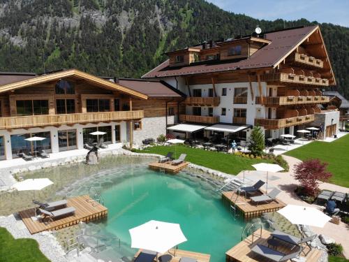 a hotel with a swimming pool in front of a building at NOVA Moments Boutique Hotel in Pertisau