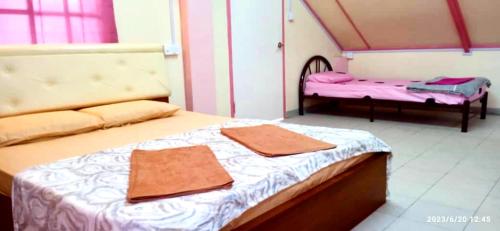 Dongorit Cabin Deluxe Room في Kampong Kundassan: غرفة نوم بسريرين عليها مناشف