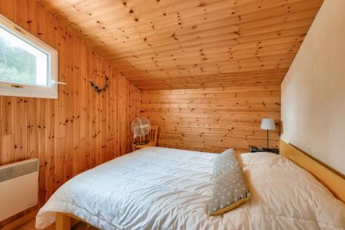 ein Schlafzimmer mit einem Bett in einem Holzzimmer in der Unterkunft Cocon au calme, entre foret et plage in La Faute-sur-Mer