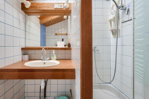 une salle de bain avec un lavabo et une douche dans l'établissement À 600m de la plage, maison pour 6 avec piscine, à La Faute-sur-Mer