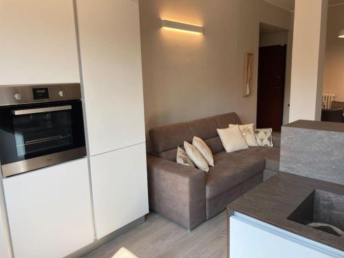 uma sala de estar com um sofá e uma cozinha em SUITE DE ROLANDIS CirOO5005OO199 em Asti