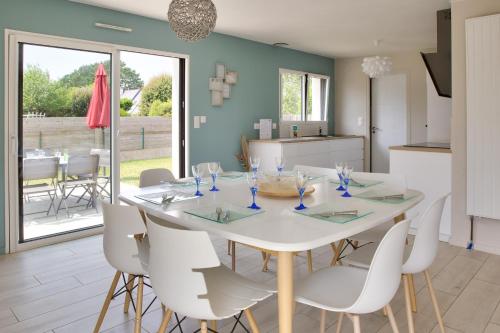 une cuisine et une salle à manger avec une table et des chaises blanches dans l'établissement Maison pour 8 avec jardin à 1km de la plage, à Plobannalec-Lesconil