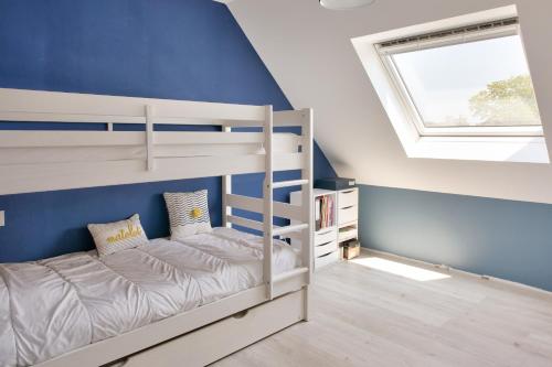1 Schlafzimmer mit 2 Etagenbetten und einem Fenster in der Unterkunft Calme, detente et decouvertes en famille in Plobannalec-Lesconil