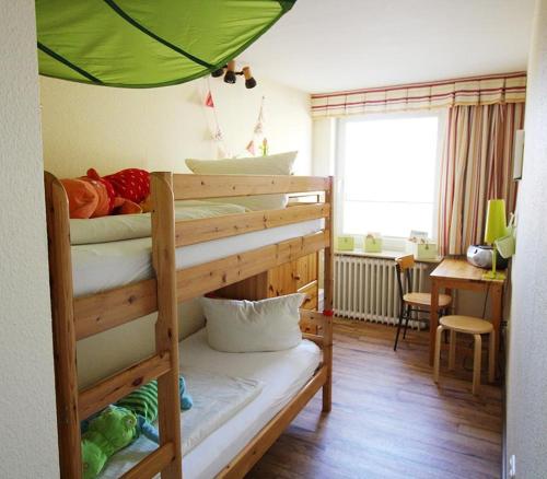 a bedroom with a bunk bed with a green umbrella at Adlerhorst in Bliesdorf