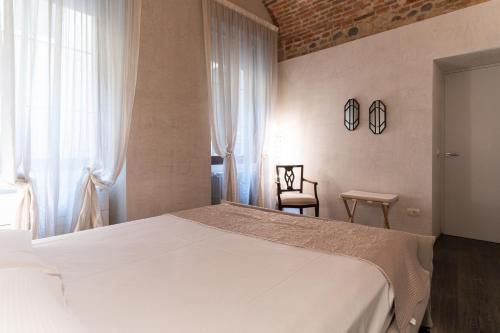 ein Schlafzimmer mit einem großen weißen Bett und einem Fenster in der Unterkunft Rosa Luxury Apartment in Verona