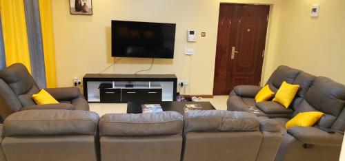 Una televisión o centro de entretenimiento en Jacaranda Gardens Furnished Apartments