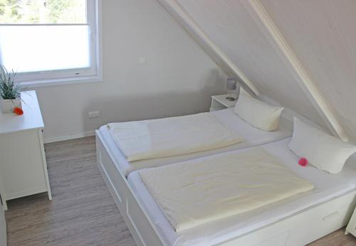 RettinにあるTraumblickの白い部屋で、ベッド2台、窓が備わります。