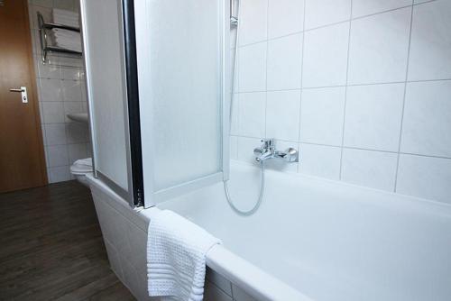 a white bathroom with a shower and a sink at Gänseblümchen in Bliesdorf