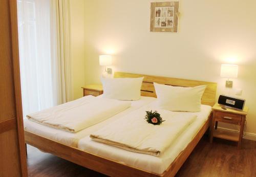 ein Schlafzimmer mit einem Bett mit einer Blume darauf in der Unterkunft Ankerplatz in Grömitz