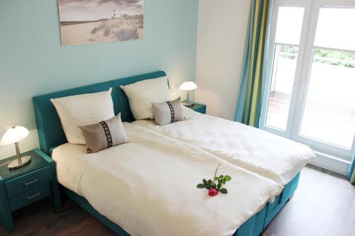 a bedroom with a large bed with a flower on it at Penthouse Parkblick in Grömitz